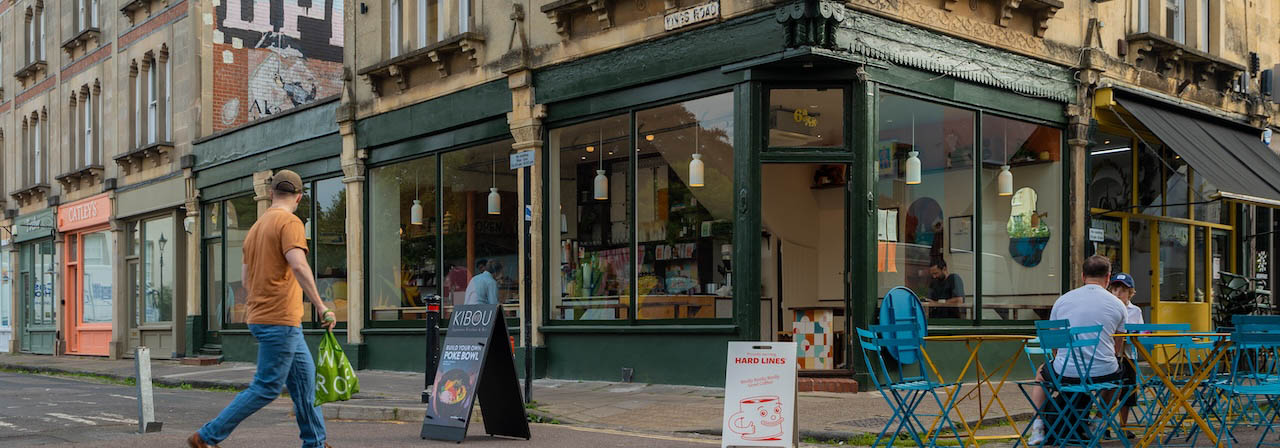 a street corner in north bristol with independent shops and outdoor seating